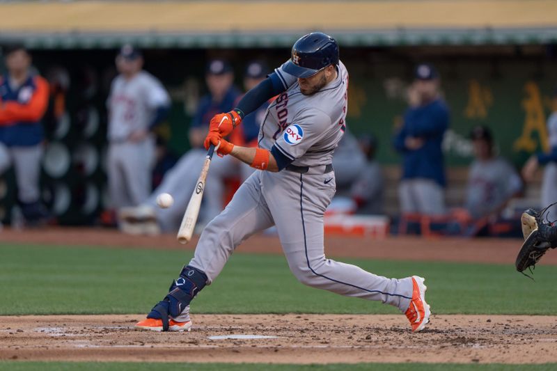 Jul 23, 2024; Oakland, California, USA;  Houston Astros catcher Victor Caratini (17) hits a solo home run during the third inning against the Oakland Athletics at Oakland-Alameda County Coliseum. Mandatory Credit: Stan Szeto-USA TODAY Sports