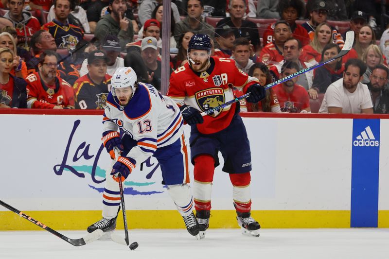 Jun 10, 2024; Sunrise, Florida, USA; Edmonton Oilers forward Mattias Janmark (13) controls the puck against Florida Panthers forward Matthew Tkachuk (19) during the second period in game two of the 2024 Stanley Cup Final at Amerant Bank Arena. Mandatory Credit: Sam Navarro-USA TODAY Sports