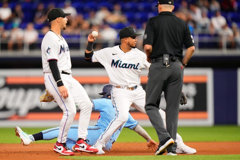 Jun 20, 2023; Miami, Florida, USA; Miami Marlins second baseman Luis Arraez (3) tags out Toronto Blue Jays second baseman Whit Merrifield (15) during the fifth inning at loanDepot Park. Mandatory Credit: Rich Storry-USA TODAY Sports