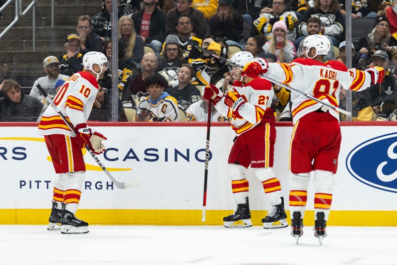 Oct 14, 2023; Pittsburgh, Pennsylvania, USA; Calgary Flames center Jonathan Huberdeau (10) and center Nazem Kadri (91) celebrate a goal by right winger Matt Coronato (27) against the Pittsburgh Penguins during the second period at PPG Paints Arena. Mandatory Credit: Scott Galvin-USA TODAY Sports