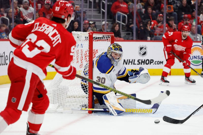 Feb 24, 2024; Detroit, Michigan, USA;  Detroit Red Wings right wing Alex DeBrincat (93) crosses the puck in front of St. Louis Blues goaltender Joel Hofer (30) in the second period at Little Caesars Arena. Mandatory Credit: Rick Osentoski-USA TODAY Sports