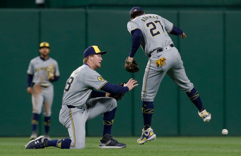 Apr 24, 2024; Pittsburgh, Pennsylvania, USA;  A ball hit by Pittsburgh Pirates shortstop Oneil Cruz (not pictured) falls between Milwaukee Brewers left fielder Joey Wiemer (28) and shortstop Willy Adames (27) for a single during the ninth inning at PNC Park. The Brewers won 3-2. Mandatory Credit: Charles LeClaire-USA TODAY Sports