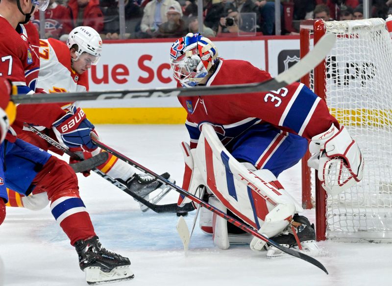 Nov 14, 2023; Montreal, Quebec, CAN; Calgary Flames forward Connor Zary (47) scores a goal against Montreal Canadiens goalie Sam Montembeault (35) during the second period at the Bell Centre. Mandatory Credit: Eric Bolte-USA TODAY Sports