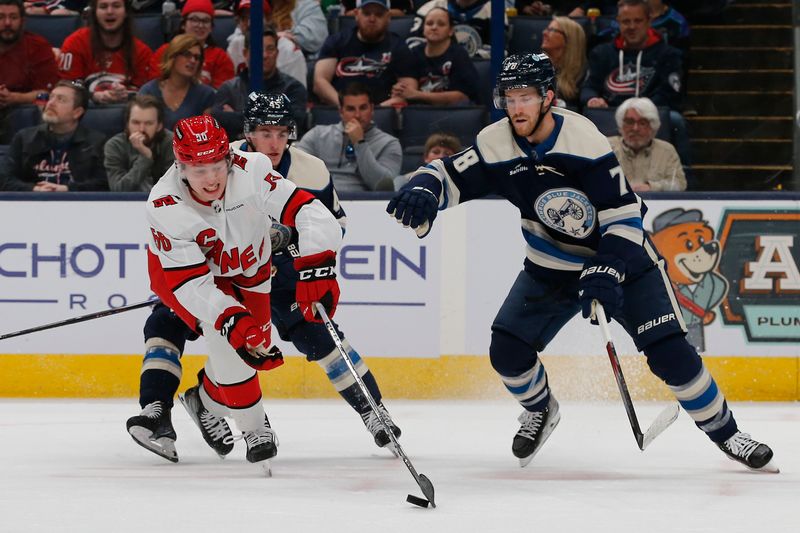 Apr 16, 2024; Columbus, Ohio, USA; Carolina Hurricanes defenseman Scott Morrow (56) carries the puck away from Columbus Blue Jackets defenseman Damon Severson (78) during the first period at Nationwide Arena. Mandatory Credit: Russell LaBounty-USA TODAY Sports