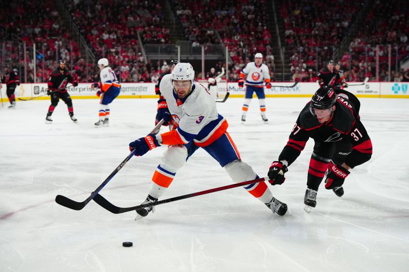 Apr 30, 2024; Raleigh, North Carolina, USA; New York Islanders defenseman Adam Pelech (3) skates with the puck against Carolina Hurricanes right wing Andrei Svechnikov (37) during the third period in game five of the first round of the 2024 Stanley Cup Playoffs at PNC Arena. Mandatory Credit: James Guillory-USA TODAY Sports