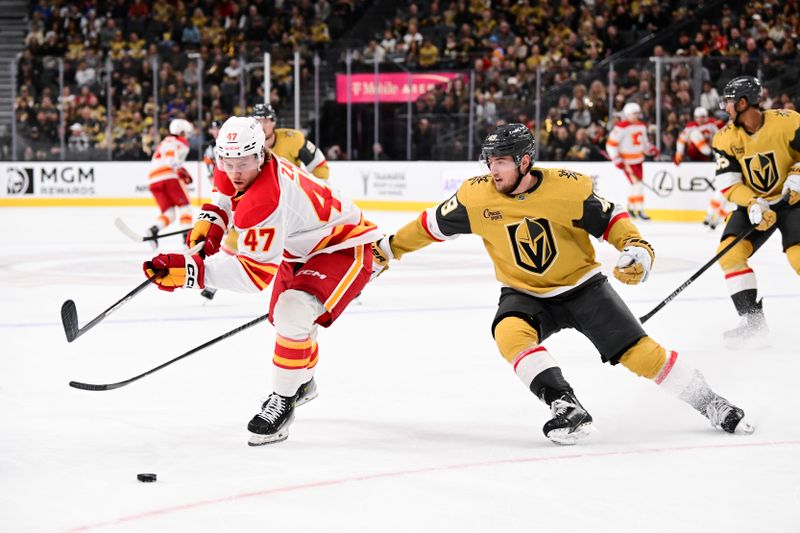 Oct 28, 2024; Las Vegas, Nevada, USA; Calgary Flames center Connor Zary (47) and Vegas Golden Knights center Ivan Barbashev (49) chase after the puck in the first period of their game at T-Mobile Arena. Mandatory Credit: Candice Ward-Imagn Images