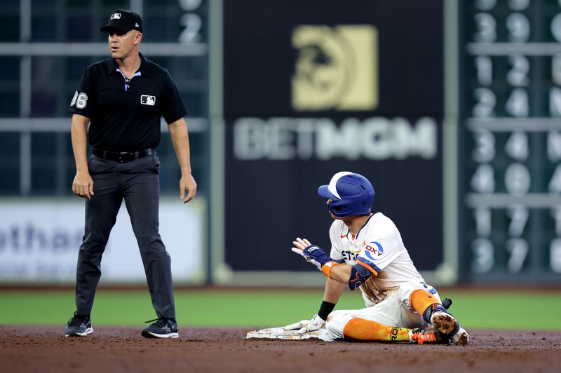 Apr 13, 2025; Houston, Texas, USA; Houston Astros second baseman Mauricio Dubon (14) signals to second base umpire Chris Segal (96) after hitting an RBI double against the Los Angeles Angels during the second inning at Daikin Park. Mandatory Credit: Erik Williams-Imagn Images