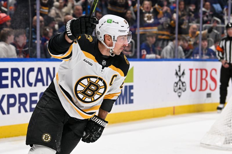 Nov 27, 2024; Elmont, New York, USA;  Boston Bruins left wing Brad Marchand (63) celebrates his second goal against the New York Islanders during the first period at UBS Arena. Mandatory Credit: Dennis Schneidler-Imagn Images