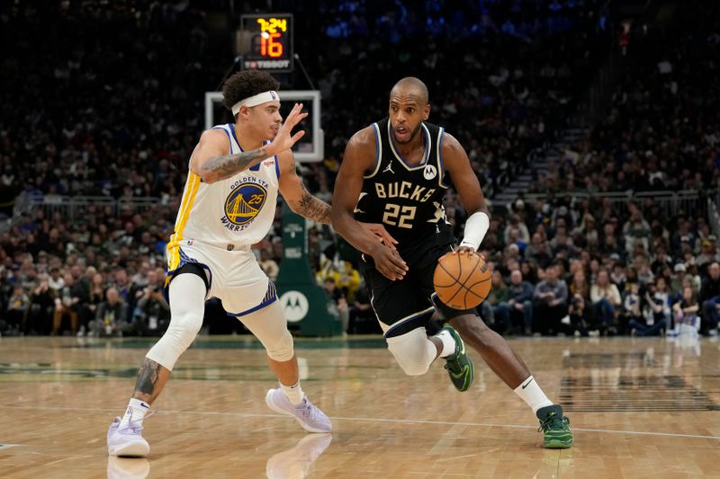 MILWAUKEE, WISCONSIN - JANUARY 13: Khris Middleton #22 of the Milwaukee Bucks dribbles the ball against Lester Quinones #25 of the Golden State Warriors in the second half at Fiserv Forum on January 13, 2024 in Milwaukee, Wisconsin. NOTE TO USER: User expressly acknowledges and agrees that, by downloading and or using this photograph, User is consenting to the terms and conditions of the Getty Images License Agreement. (Photo by Patrick McDermott/Getty Images)