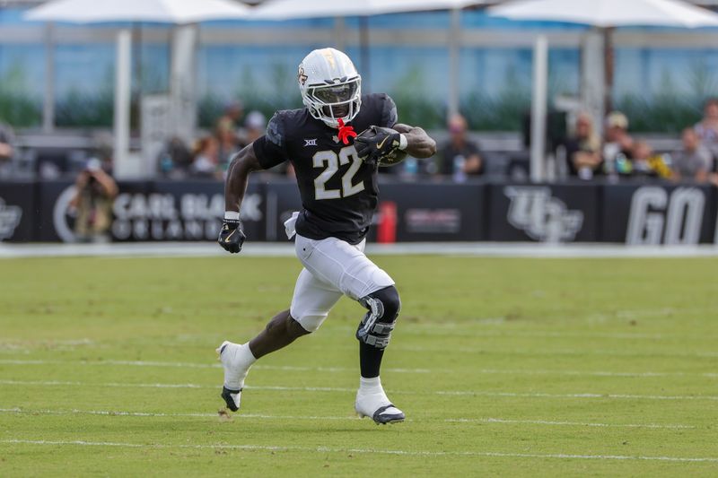 Oct 12, 2024; Orlando, Florida, USA; UCF Knights running back Myles Montgomery (22) runs the ball during the first quarter against the Cincinnati Bearcats at FBC Mortgage Stadium. Mandatory Credit: Mike Watters-Imagn Images