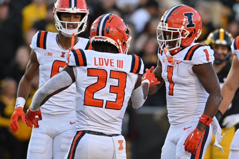 Nov 18, 2023; Iowa City, Iowa, USA; Illinois Fighting Illini running back Reggie Love III (23) celebrates with wide receiver Isaiah Williams (1) after scoring a rushing touchdown against the Iowa Hawkeyes during the second quarter at Kinnick Stadium. Mandatory Credit: Jeffrey Becker-USA TODAY Sports