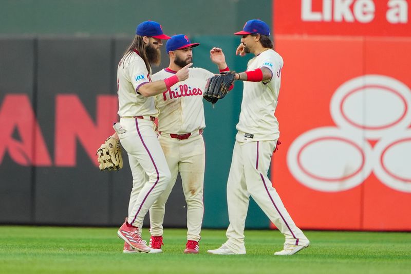 Sep 14, 2024; Philadelphia, Pennsylvania, USA; Philadelphia Phillies left fielder Brandon Marsh (16) and center fielder Cal Stevenson (47) and right fielder Nick Castellanos (8) celebrate after defeating the New York Mets at Citizens Bank Park. Mandatory Credit: Gregory Fisher-Imagn Images