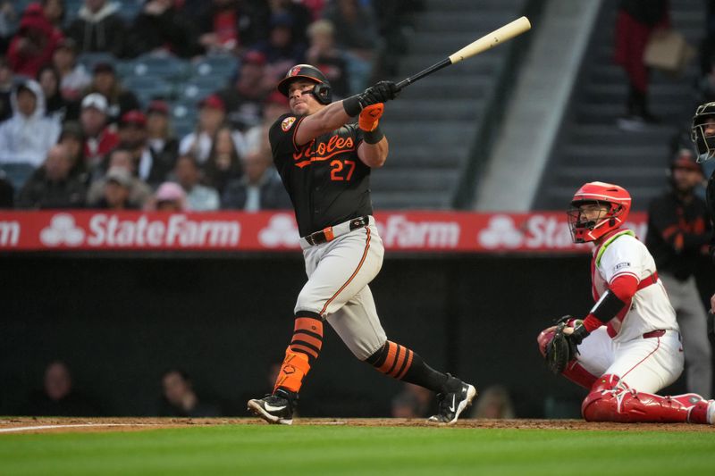 Apr 22, 2024; Anaheim, California, USA; Baltimore Orioles catcher James McCann (27) follows through on a solo home run in the second inning against the Los Angeles Angels at Angel Stadium. Mandatory Credit: Kirby Lee-USA TODAY Sports