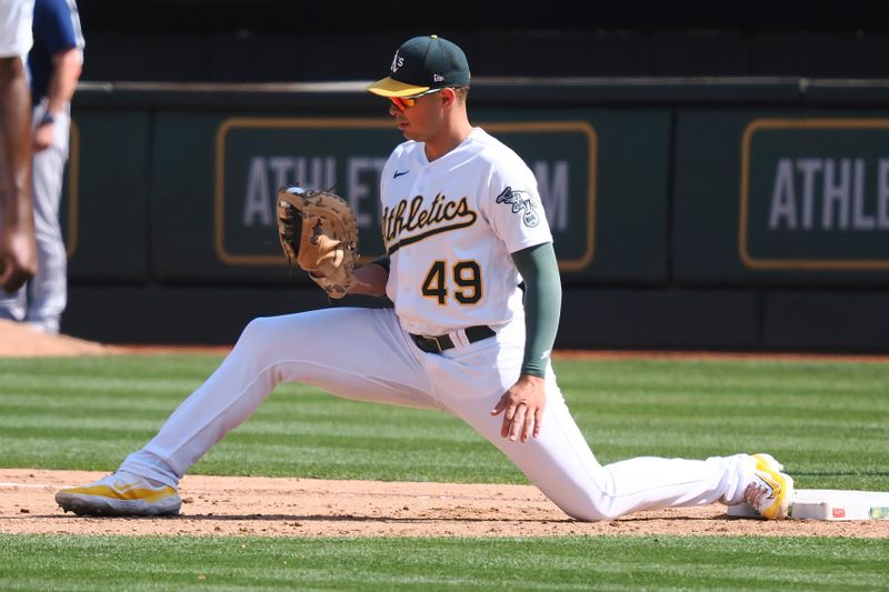 Sep 20, 2023; Oakland, California, USA; Oakland Athletics first baseman Ryan Noda (49) looks at his glove after making an out against the Seattle Mariners during the eighth inning at Oakland-Alameda County Coliseum. Mandatory Credit: Kelley L Cox-USA TODAY Sports