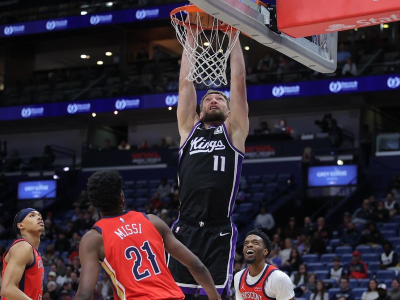 NEW ORLEANS, LOUISIANA - DECEMBER 12: Domantas Sabonis #11 of the Sacramento Kings dunks as Yves Missi #21 of the New Orleans Pelicans defends during the first half at the Smoothie King Center on December 12, 2024 in New Orleans, Louisiana. NOTE TO USER: User expressly acknowledges and agrees that, by downloading and or using this Photograph, user is consenting to the terms and conditions of the Getty Images License Agreement. (Photo by Jonathan Bachman/Getty Images)