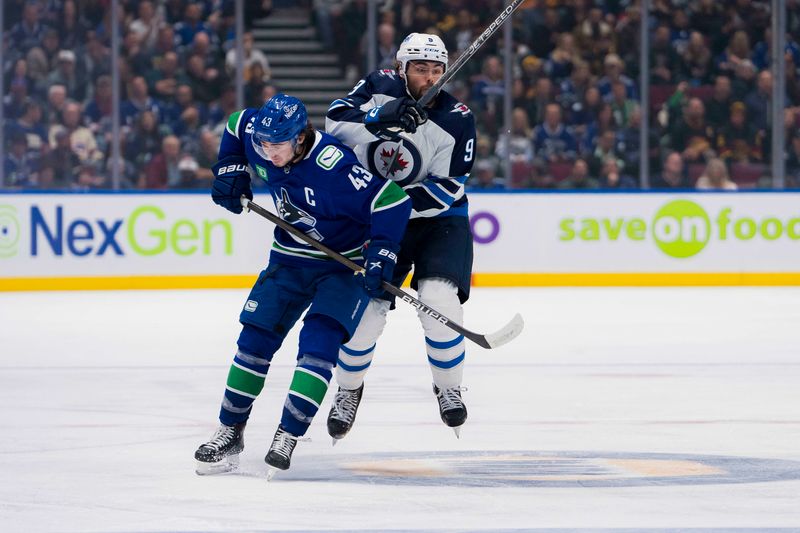 Feb 17, 2024; Vancouver, British Columbia, CAN; Vancouver Canucks defenseman Quinn Hughes (43) checks Winnipeg Jets forward Alex Iafallo (9) in the third period at Rogers Arena. Jets won 4-2. Mandatory Credit: Bob Frid-USA TODAY Sports