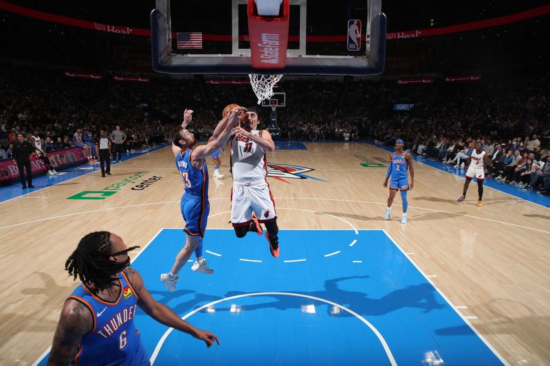 OKLAHOMA CITY, OK - MARCH 8:  Jaime Jaquez Jr. #11 of the Miami Heat drives to the basket during the game as Gordon Hayward #33 of the Oklahoma City Thunder plays defense on March 8, 2024 at Paycom Arena in Oklahoma City, Oklahoma. NOTE TO USER: User expressly acknowledges and agrees that, by downloading and or using this photograph, User is consenting to the terms and conditions of the Getty Images License Agreement. Mandatory Copyright Notice: Copyright 2024 NBAE (Photo by Zach Beeker/NBAE via Getty Images)