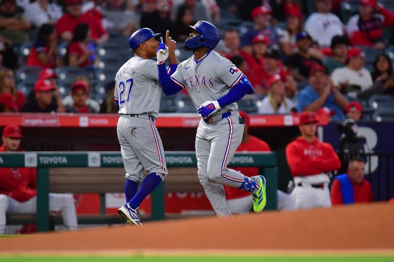 Sep 27, 2024; Anaheim, California, USA; Texas Rangers right fielder Adolis Garcia (53) is greeted by third base coach Tony Beasley (27) after hitting a solo home run against the Los Angeles Angels. during the first inning at Angel Stadium. Mandatory Credit: Gary A. Vasquez-Imagn Images