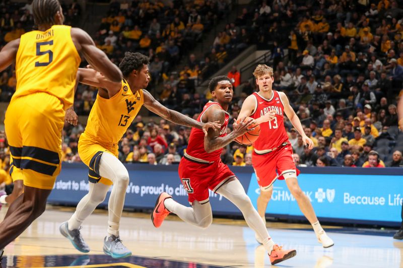 Jan 7, 2025; Morgantown, West Virginia, USA; Arizona Wildcats guard Caleb Love (1) drives down the lane past West Virginia Mountaineers forward Amani Hansberry (13) during the second half at WVU Coliseum. Mandatory Credit: Ben Queen-Imagn Images