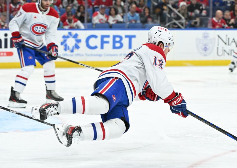 Nov 11, 2024; Buffalo, New York, USA; Montreal Canadiens right wing Cole Caufield (13) is tripped by a Buffalo Sabres player in the second period at KeyBank Center. Mandatory Credit: Mark Konezny-Imagn Images