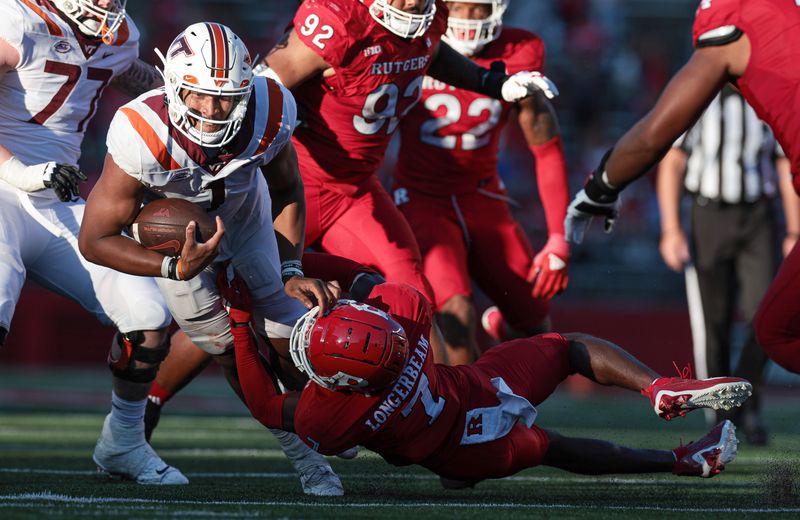 Sep 16, 2023; Piscataway, New Jersey, USA; Virginia Tech Hokies quarterback Kyron Drones (1) is tackled by Rutgers Scarlet Knights defensive back Robert Longerbeam (7) during the second half at SHI Stadium. Mandatory Credit: Vincent Carchietta-USA TODAY Sports