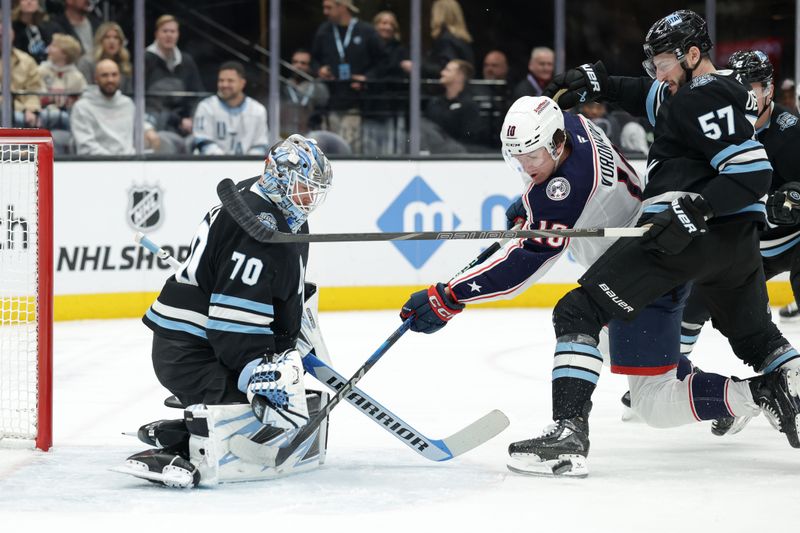 Jan 31, 2025; Salt Lake City, Utah, USA;  Columbus Blue Jackets left wing Dmitri Voronkov (10) misses the puck after it was blocked by Utah Hockey Club goaltender Karel Vejmelka (70) during the first period at Delta Center. Mandatory Credit: Chris Nicoll-Imagn Images