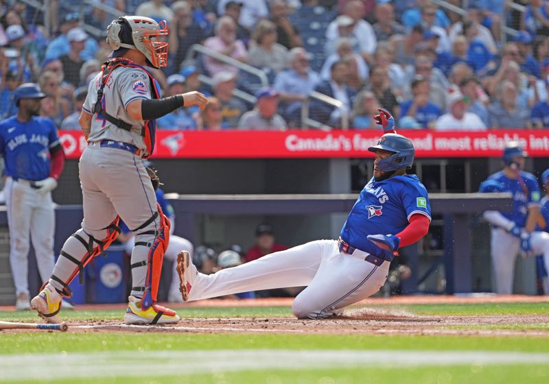 Sep 11, 2024; Toronto, Ontario, CAN; Toronto Blue Jays first baseman Vladimir Guerrero Jr. (27) slides into home plate scoring a run against the New York Mets during the fourth inning at Rogers Centre. Mandatory Credit: Nick Turchiaro-Imagn Images