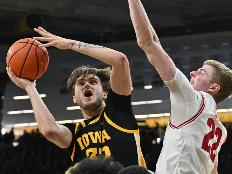 Feb 17, 2024; Iowa City, Iowa, USA; Iowa Hawkeyes forward Owen Freeman (32) shoots the ball as Wisconsin Badgers forward Steven Crowl (22) defends during the second half at Carver-Hawkeye Arena. Mandatory Credit: Jeffrey Becker-USA TODAY Sports