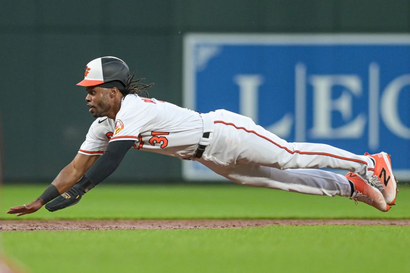 Sep 11, 2023; Baltimore, Maryland, USA; Baltimore Orioles center fielder Cedric Mullins (31) slides into third base during the second inning against the St. Louis Cardinals at Oriole Park at Camden Yards. Mandatory Credit: Tommy Gilligan-USA TODAY Sports