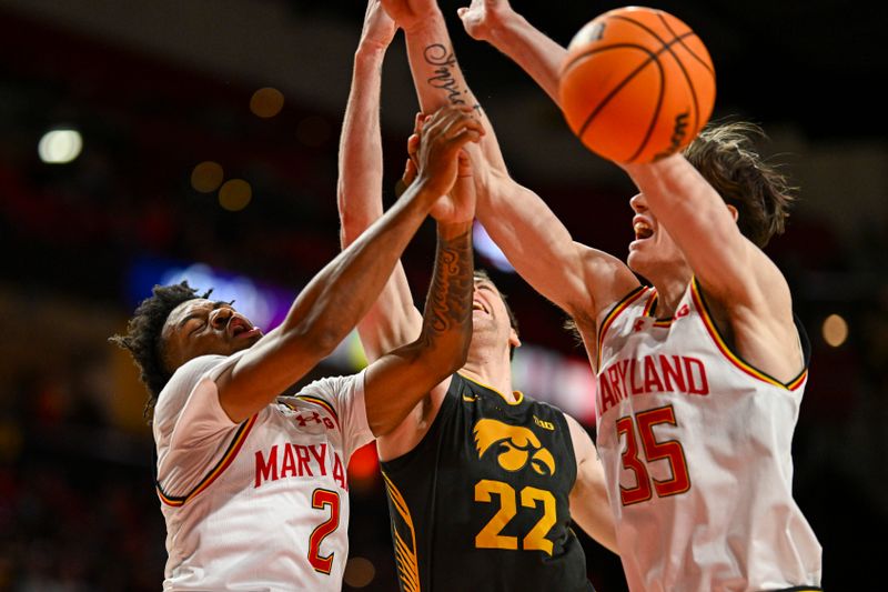 Feb 14, 2024; College Park, Maryland, USA; Iowa Hawkeyes forward Patrick McCaffery (22) reaches for a loose ball in-between Maryland Terrapins guard Jahari Long (2) and  center Caelum Swanton-Rodger (35) during the first half  at Xfinity Center. Mandatory Credit: Tommy Gilligan-USA TODAY Sports