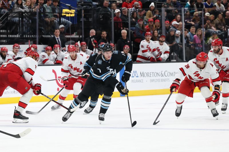 Nov 13, 2024; Salt Lake City, Utah, USA; Utah Hockey Club defenseman Michael Kesselring (7) skates with the puck against the Carolina Hurricanes during the second period at Delta Center. Mandatory Credit: Rob Gray-Imagn Images