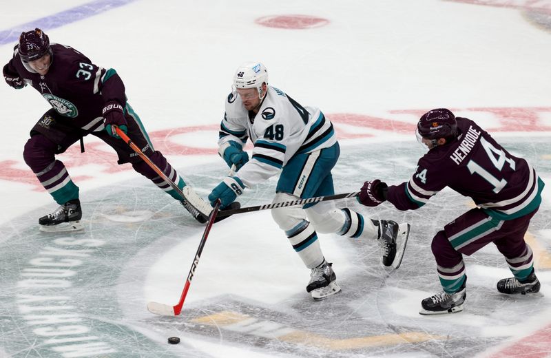 Nov 12, 2023; Anaheim, California, USA; San Jose Sharks center Tomas Hertl (48) skates the puck between Anaheim Ducks right wing Jakob Silfverberg (33) and center Adam Henrique (14) during the third period at Honda Center. Mandatory Credit: Jason Parkhurst-USA TODAY Sports