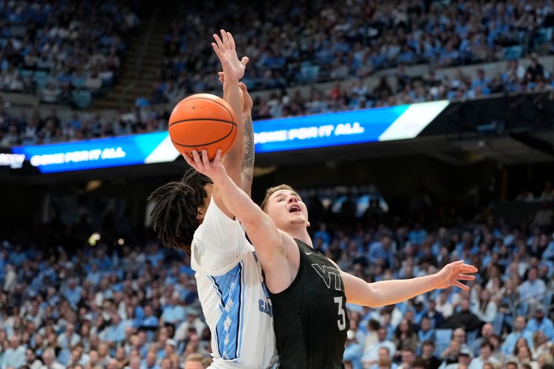 Feb 17, 2024; Chapel Hill, North Carolina, USA; Virginia Tech Hokies guard Sean Pedulla (3) shoots as North Carolina Tar Heels guard Elliot Cadeau (2) defends in the first half at Dean E. Smith Center. Mandatory Credit: Bob Donnan-USA TODAY Sports