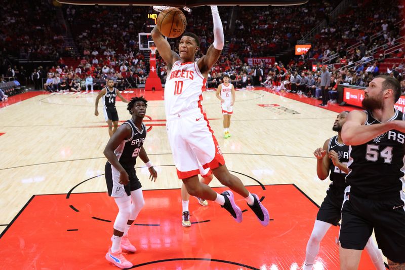 HOUSTON, TEXAS - OCTOBER 17: Jabari Smith Jr. #10 of the Houston Rockets slam dunks the ball over Sidy Cissoko #25 of the San Antonio Spurs during the first half of a preseason game at Toyota Center on October 17, 2024 in Houston, Texas. NOTE TO USER: User expressly acknowledges and agrees that, by downloading and or using this photograph, User is consenting to the terms and conditions of the Getty Images License Agreement. (Photo by Alex Slitz/Getty Images)