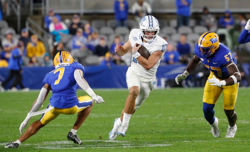 Sep 23, 2023; Pittsburgh, Pennsylvania, USA; North Carolina Tar Heels quarterback Drake Maye (10) runs the ball as Pittsburgh Panthers defensive back Javon McIntyre (7) and defensive lineman Bam Brima (57) defend during the first quarter at Acrisure Stadium. Mandatory Credit: Charles LeClaire-USA TODAY Sports