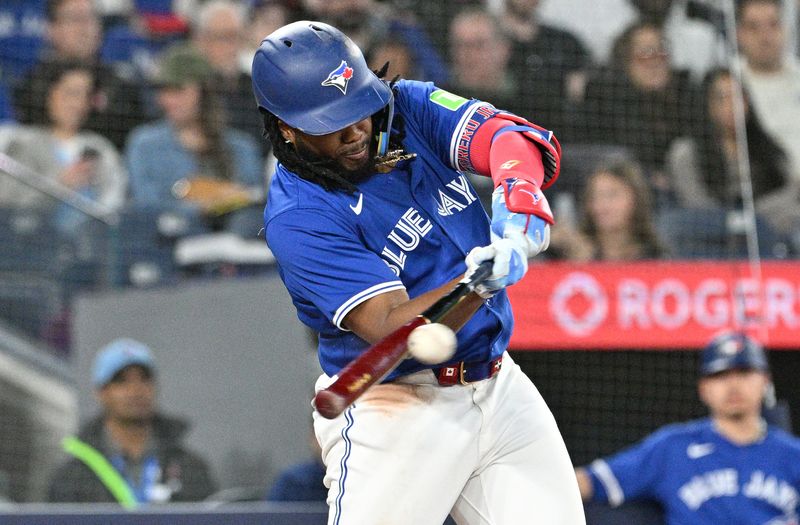 Apr 13, 2024; Toronto, Ontario, CAN;  Toronto Blue Jays first baseman Vladimir Guerrero Jr. (27) hits a single against the Colorado Rockies in the seventh inning at Rogers Centre. Mandatory Credit: Dan Hamilton-USA TODAY Sports