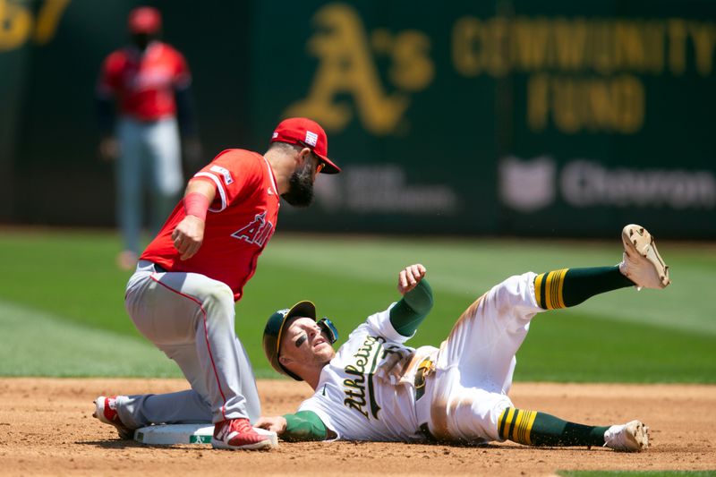 Jul 20, 2024; Oakland, California, USA; Los Angeles Angels shortstop Zach Neto (9) tags out Oakland Athletics third baseman Brett Harris (77) as he attempts to steal second base during the second inning at Oakland-Alameda County Coliseum. Mandatory Credit: D. Ross Cameron-USA TODAY Sports