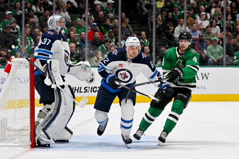 Feb 29, 2024; Dallas, Texas, USA; Dallas Stars defenseman Miro Heiskanen (4) and Winnipeg Jets center Mason Appleton (22) skate in front of goaltender Connor Hellebuyck (37) during the second period at the American Airlines Center. Mandatory Credit: Jerome Miron-USA TODAY Sports