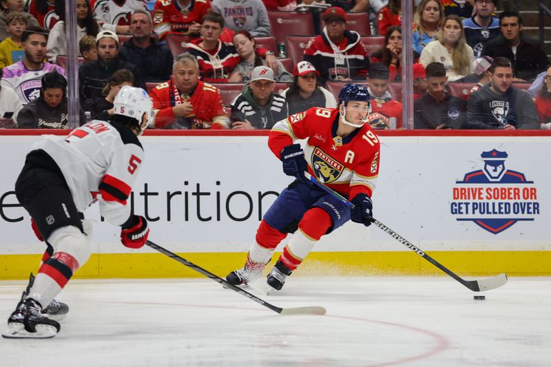 Nov 14, 2024; Sunrise, Florida, USA; Florida Panthers left wing Matthew Tkachuk (19) moves the puck against the New Jersey Devils during the second period at Amerant Bank Arena. Mandatory Credit: Sam Navarro-Imagn Images