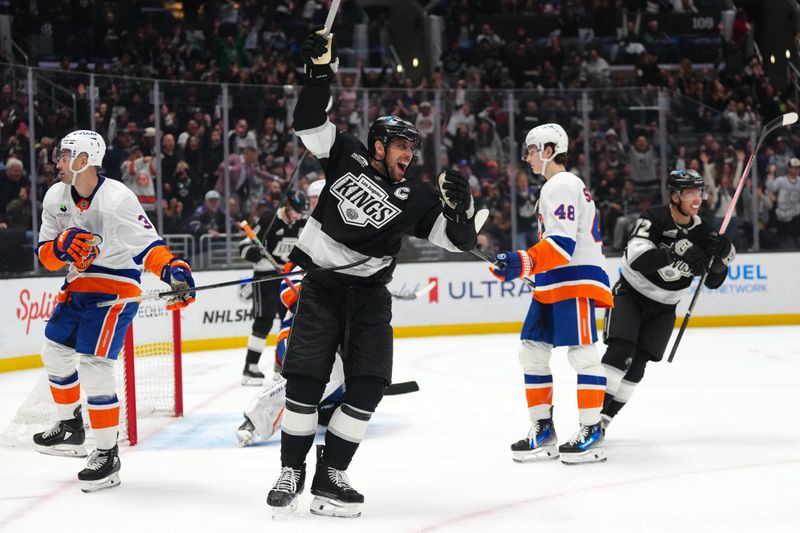 Mar 5, 2026; Los Angeles, California, USA; LA Kings center Anze Kopitar (11) celebrates after a goal as New York Islanders defenseman Adam Pelech (3) and defenseman Carson Soucy (4)8 react in the second period at Crypto.com Arena. Mandatory Credit: Kirby Lee-Imagn Images