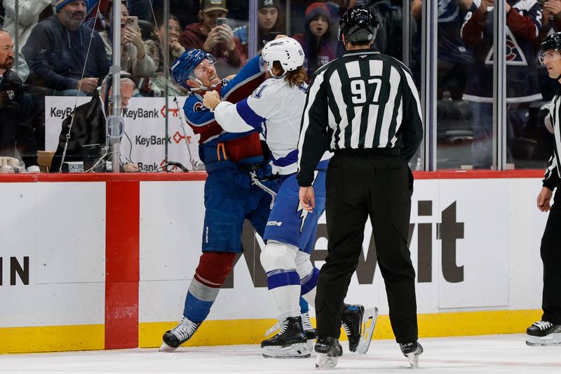 Nov 4, 2025; Denver, Colorado, USA; Tampa Bay Lightning defenseman Charle-Edouard D'Astous (51) an dColorado Avalanche left wing Gabriel Landeskog (92) fight as linesman Jeremy Faucher (97) looks on in the first period at Ball Arena. Mandatory Credit: Isaiah J. Downing-Imagn Images