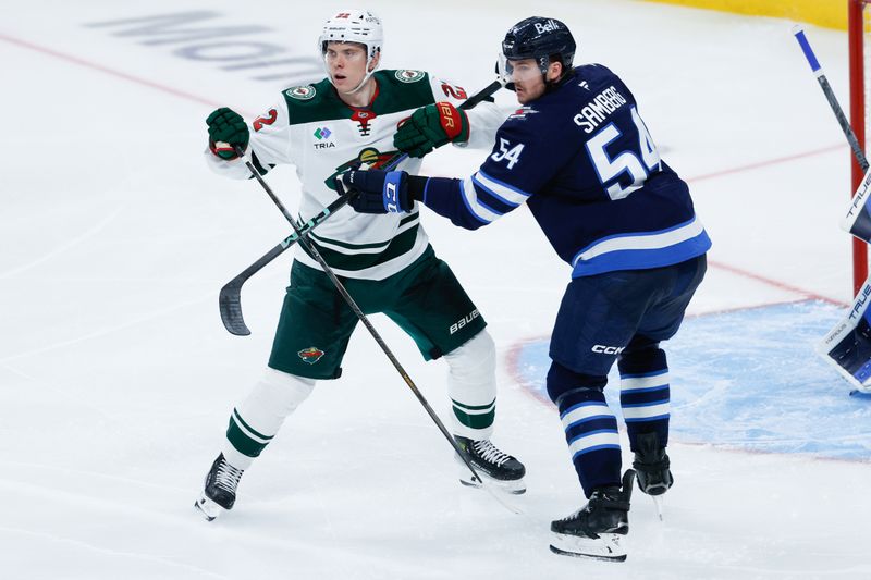 Nov 23, 2025; Winnipeg, Manitoba, CAN;  Winnipeg Jets defenseman Dylan Samberg (54) jostles for position with Minnesota Wild forward Danila Yurov (22) during the third period at Canada Life Centre. Mandatory Credit: Terrence Lee-Imagn Images