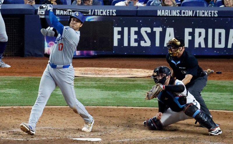 Sep 19, 2024; Miami, Florida, USA;   Los Angeles Dodgers designated hitter Shohei Ohtani (17) hits his 50th home run of the season against the Miami Marlins during the seventh inning at loanDepot Park. Mandatory Credit: Rhona Wise-Imagn Images