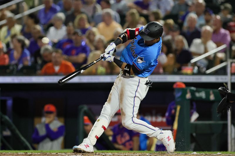 Mar 8, 2024; Jupiter, Florida, USA; Miami Marlins second baseman Luis Arraez (3) hits a single against the New York Mets during the third inning at Roger Dean Chevrolet Stadium. Mandatory Credit: Sam Navarro-USA TODAY Sports
