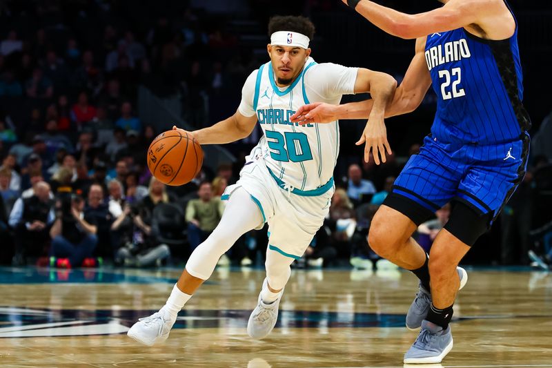 CHARLOTTE, NORTH CAROLINA - NOVEMBER 25: Seth Curry #30 of the Charlotte Hornets drives by Franz Wagner #22 of the Orlando Magic during the second first half of a basketball game at Spectrum Center on November 25, 2024 in Charlotte, North Carolina. NOTE TO USER: User expressly acknowledges and agrees that, by downloading and or using this photograph, User is consenting to the terms and conditions of the Getty Images License Agreement. (Photo by David Jensen/Getty Images)