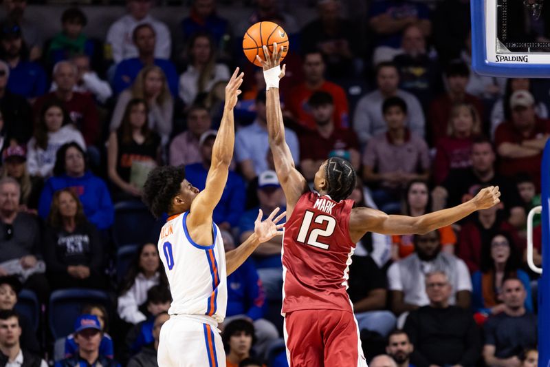 Jan 13, 2024; Gainesville, Florida, USA; Arkansas Razorbacks guard Tramon Mark (12) blocks a shot by Florida Gators guard Zyon Pullin (0) during the first half at Exactech Arena at the Stephen C. O'Connell Center. Mandatory Credit: Matt Pendleton-USA TODAY Sports