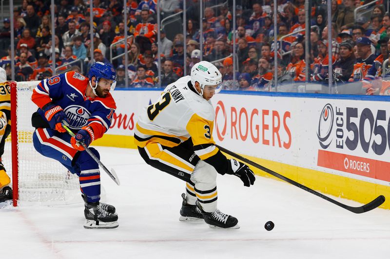 Oct 25, 2024; Edmonton, Alberta, CAN; Edmonton Oilers forward Adam Henrique (19) and Pittsburgh Penguins defensemen Jack St.Ivany (3) battle along the boards for a loose puck during the first period at Rogers Place. Mandatory Credit: Perry Nelson-Imagn Images