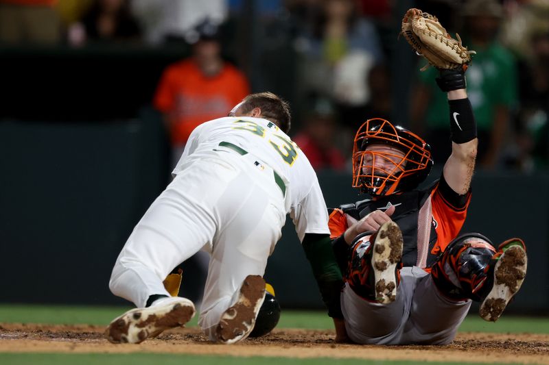 Jun 7, 2025; West Sacramento, California, USA; Baltimore Orioles catcher Maverick Handley (98) raises his glove with the ball after tagging out Athletics left fielder JJ Bleday (33) during the fifth inning at Sutter Health Park. Mandatory Credit: Dennis Lee-Imagn Images