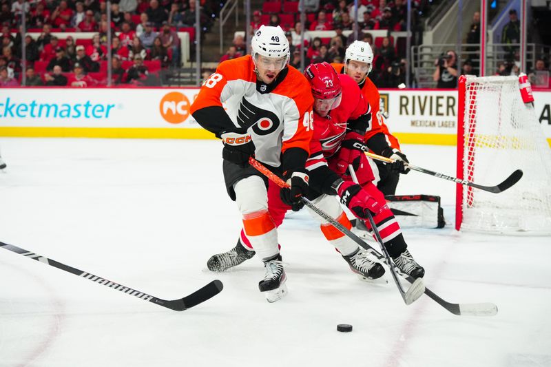 Mar 21, 2024; Raleigh, North Carolina, USA; Carolina Hurricanes right wing Stefan Noesen (23) and Philadelphia Flyers center Morgan Frost (48) battle for the puck during the first period at PNC Arena. Mandatory Credit: James Guillory-USA TODAY Sports