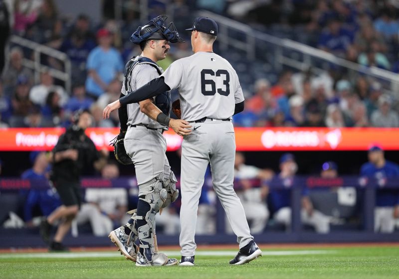 Jun 30, 2024; Toronto, Ontario, CAN; New York Yankees catcher Austin Wells (28) celebrates the win with relief pitcher Anthony Misiewicz (63) against the Toronto Blue Jays at the end of the ninth inning at Rogers Centre. Mandatory Credit: Nick Turchiaro-USA TODAY Sports